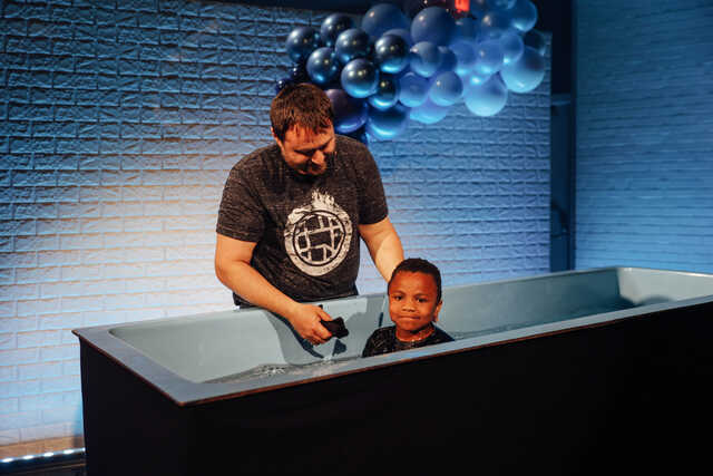 Elementary student being baptized in UpStreet.