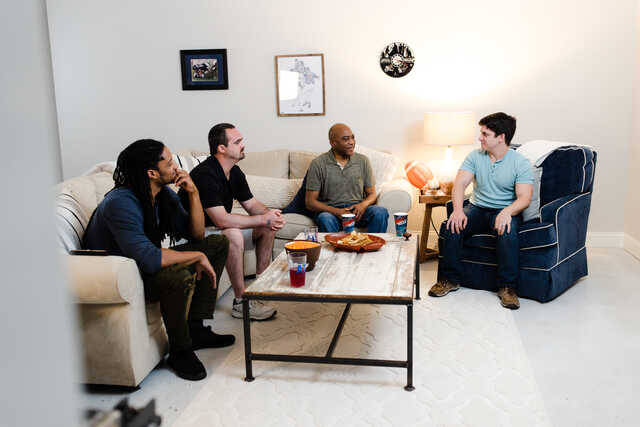 mens group sitting on couches around a coffee table